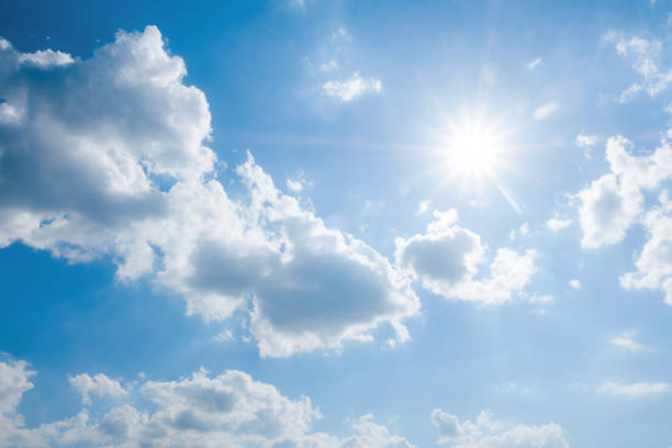 istock Beautiful blue sky with white clouds and sun, sunlight background 1199376595