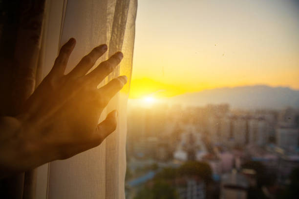 Close-up hand open window curtain in the morning Close-up hand open window curtain in the morning sunrise dawn stock pictures, royalty-free photos & images