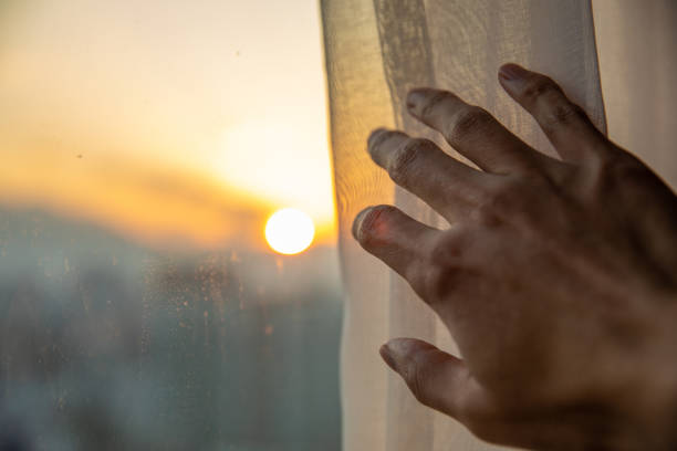 istock Close-up hand open window curtain in the morning 1199382980