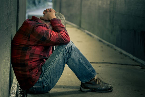 istock Depressed Homeless young man sitting in cold subway tunnel 1199384752