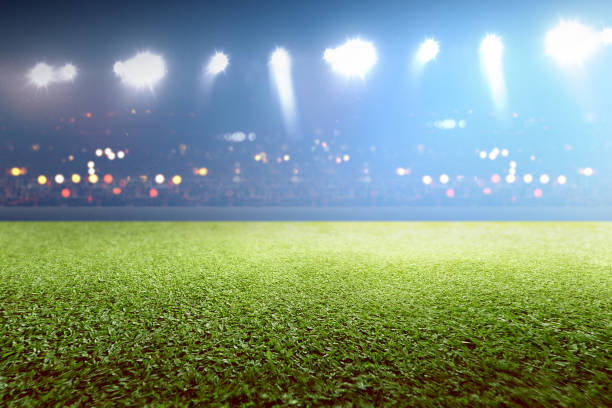 istock Green grass and tribune with blurred lights 1199386848