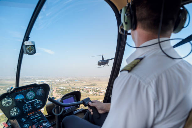 istock Pilot flying a helicopter above plain region 1199390339