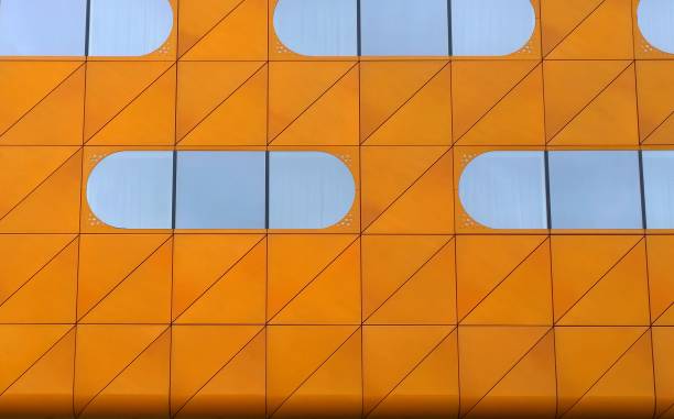 istock Orange Facade of building with oval shaped mirror windows. Modern architecture background. Beauty of skyscraper geometry, triangles and diagonal lines. Urban real estate. Design, construction industry 1199391418