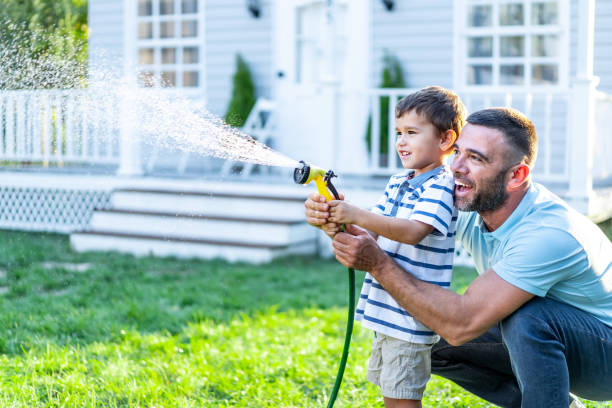 istock Father splashing water and having fun with son on back yard 1199391559