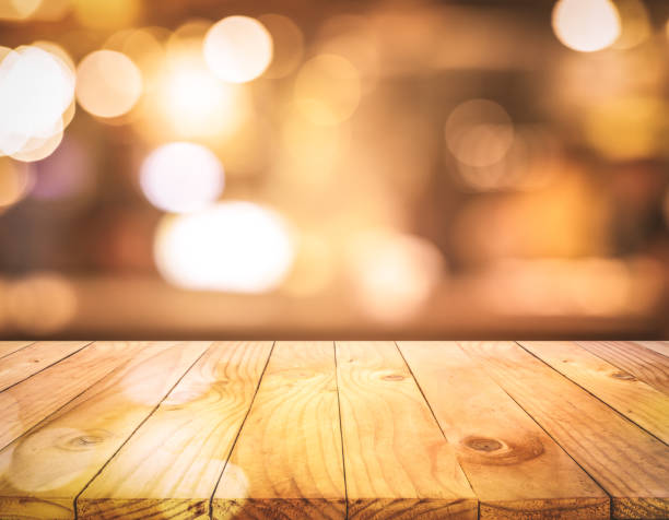 istock Wood texture table top (counter bar) with blur light gold bokeh background 1199391780
