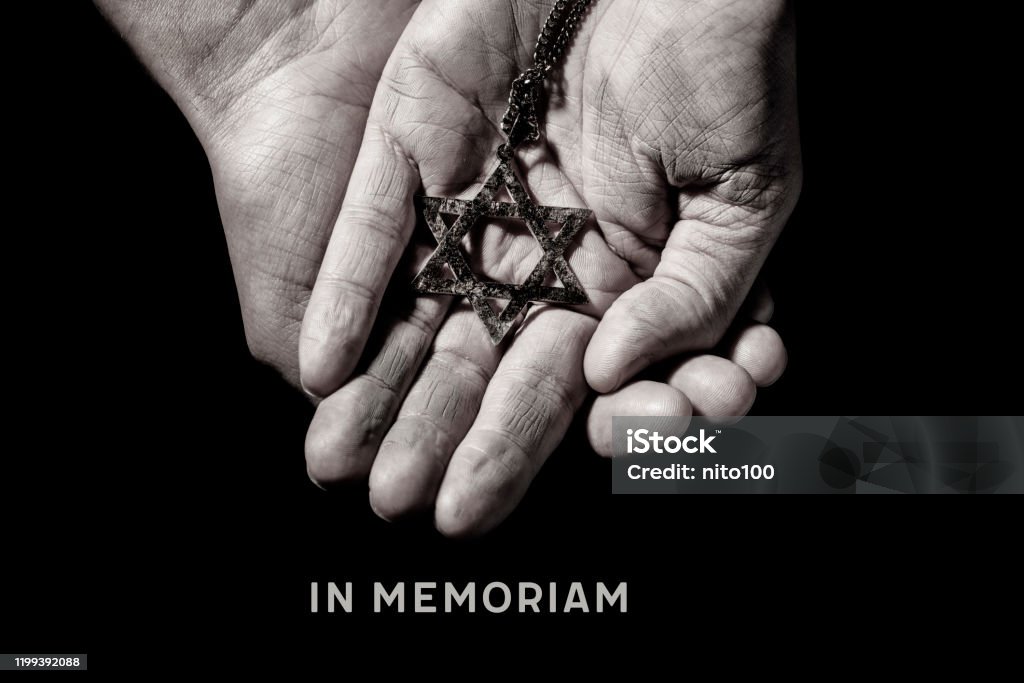 in memoriam, latin phrase equivalent to in memory an old and rusty pendant in the shape of the star of david on the hands of a man and the text in memoriam, a latin phrase equivalent to in memory, as a memory of the dead jewish people Holocaust Stock Photo