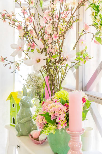 istock Easter interior decoration. Beatuful composition with candles. eggs, rabbit, birds house and blooming apple branches. 1199394120