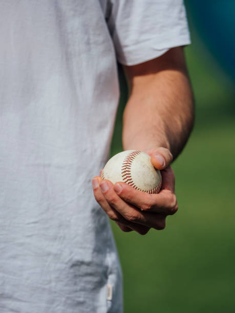 istock baseball pitcher young man holding baseball in his hand ready to throw 1199394759