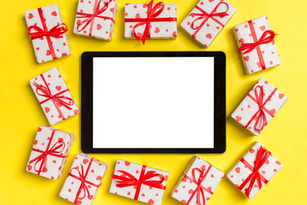 istock Top view of digital tablet surrounded with gift boxes on colorful background. Saint Valentine's day 1199397365