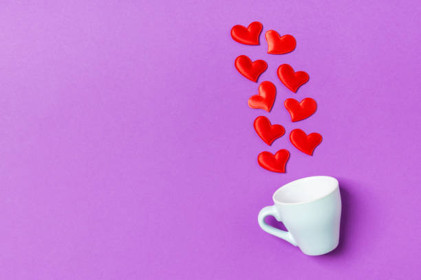 istock Top view composition of red hearts falling out from a cup on colorful background with copy space. Romantic relationship concept. St Valentaine's Day 1199397486