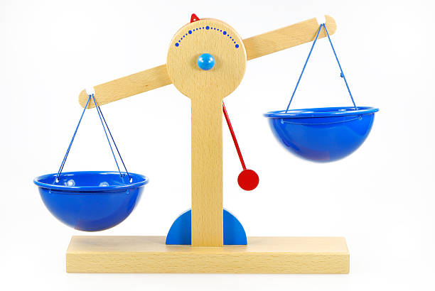 A blue and wooden pair of scales out of balance Wooden toy scales out of balance unbalance stock pictures, royalty-free photos & images