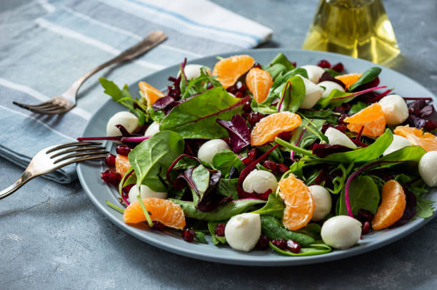 istock Fresh  mixed green salad with mandarins, pomegranate seeds and mozzarella. 1199399635