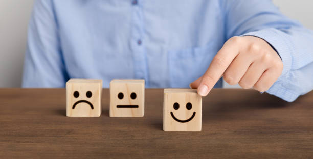 istock Customer pressing smiley face emoticon on wood cube 1199401493