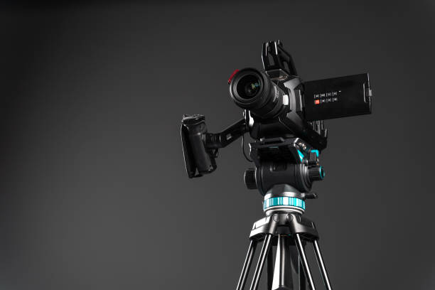 istock Professional video cinema camera on a camera tripod on black background copy space 1199401595
