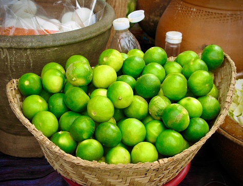 Vegetable and Herb, Fresh Persian Limes in Bamboo Basket Use for Seasoning in Cooking.