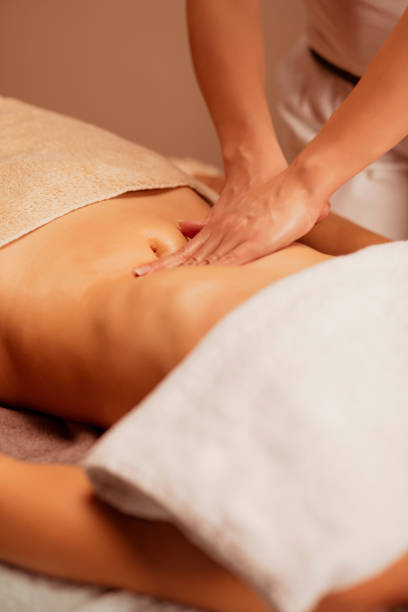 istock Belly massage. Anti cellulite massage.  Massage Therapist doing healing massage with rolling pin or battledore . Woman enjoying in relaxing massaging at health spa treatment. 1199402937