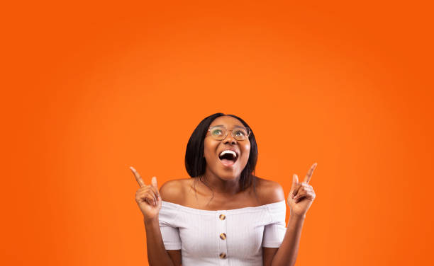 istock Excited Afro Lady Pointing Fingers Up At Empty Space, Studio 1199403003