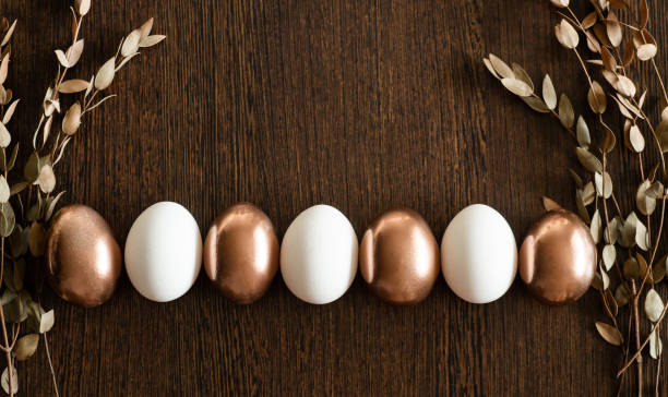 istock Flat Lay of Golden and multi-color Easter Eggs Pattern on wooden background. Easter background or easter concept 1199403408
