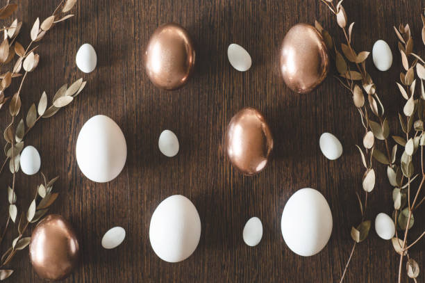 istock Flat Lay of Golden and multi-color Easter Eggs Pattern on wooden background. Easter background or easter concept 1199403490