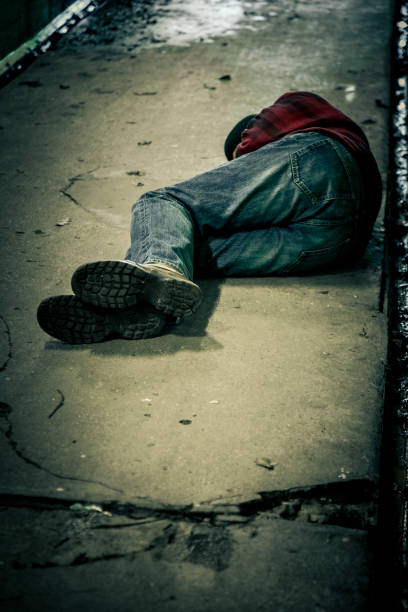 istock Homeless young man sleeping rough in cold subway tunnel 1199405898