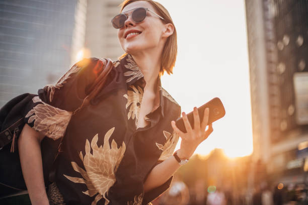 istock Young woman using her smart phone on the street 1199411889