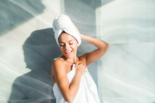 Retrato de hermosa mujer usando albornoz y toalla en la cabeza tras la ducha en casa photo