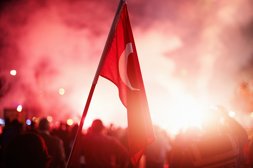 Gente abarrotada celebrando o protestando con banderas turcas en la mano photo