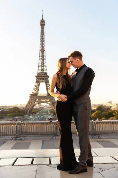 Photo of From Paris with love. Beautiful couple embracing near the Eiffel tower. Romantic date, honeymoon in France