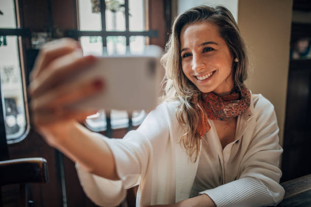 istock Beautiful woman taking a selfie in cafe 1199416255