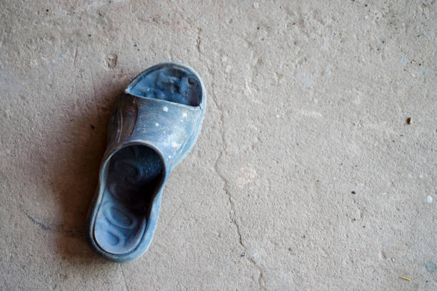 Old shoes on the cement floor, Top view.