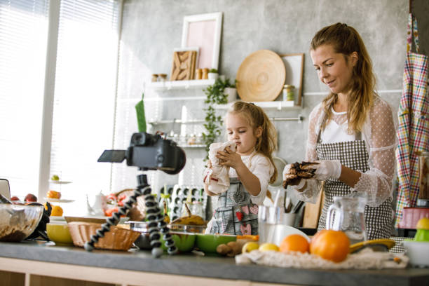istock Vlogger and her toddler daughter filming a video tutorial on how to shape and prepare cookies 1199422380
