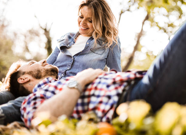 istock Young happy couple talking while relaxing in nature. 1199422713