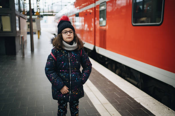 istock Little girl is waiting for train at train station 1199423949