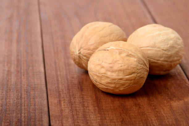 istock Ripe walnuts close-up on a brown wooden table 1199424259