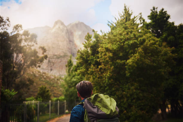 Rearview shot of a young man backpacking outdoors