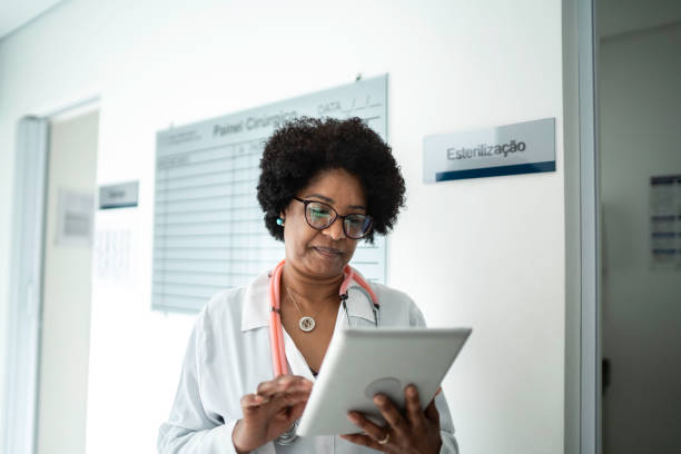 istock Mature female doctor using digital tablet at medical office 1199426672