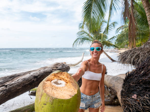 istock Couple sharing coconut on tropical beach 1199428766