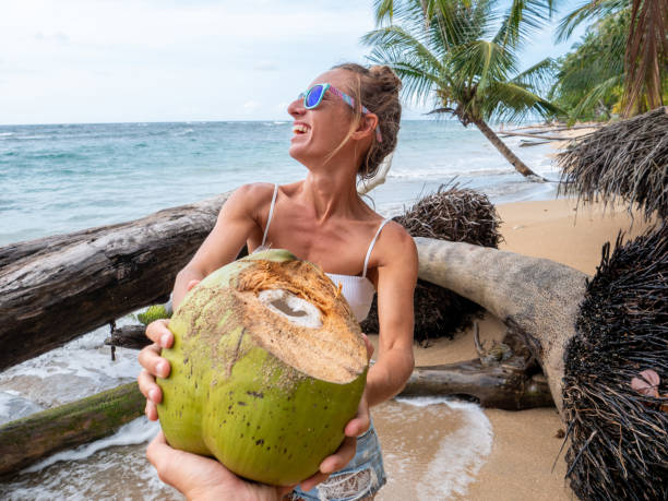 istock Couple sharing coconut on tropical beach 1199428812