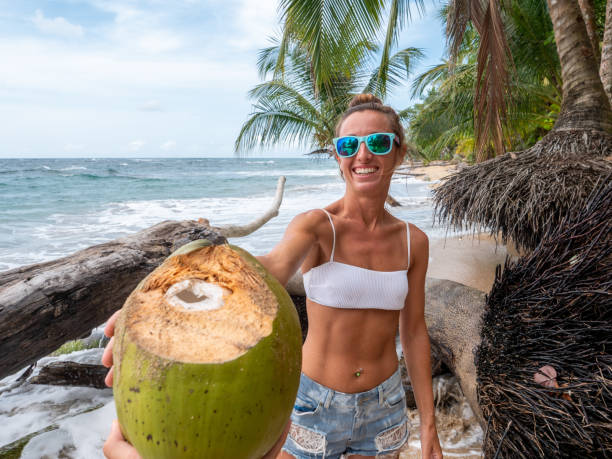 istock Couple sharing coconut on tropical beach 1199429062