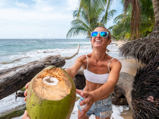 istock Couple sharing coconut on tropical beach 1199429217