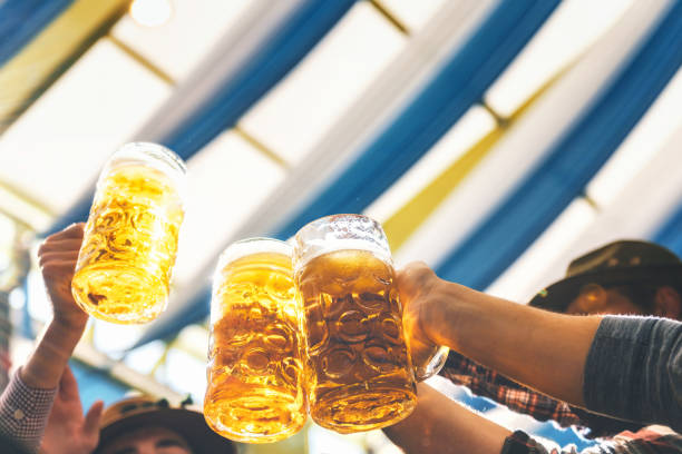 people clinking mass-beer glasses at Beer Fest in munich people clinking beer glasses at Beer Fest in munich beer festival photos stock pictures, royalty-free photos & images