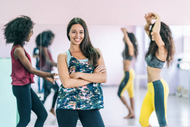 istock Female dancer standing with arms crossed in studio and posing 1199432741