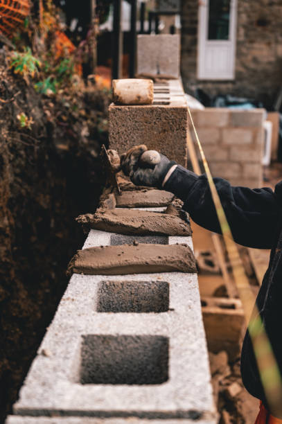 istock Labourer laying block on mortar 1199433340