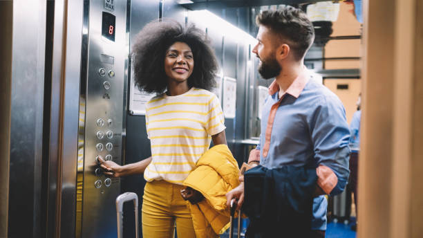 istock Young couple arriving at the hotel and using elevator 1199433441