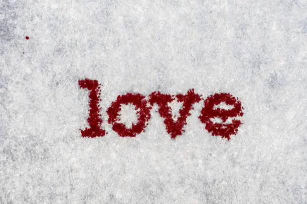 Photo of Extreme macro shot of the word LOVE typed on white paper. Grungy textured bloody mood.