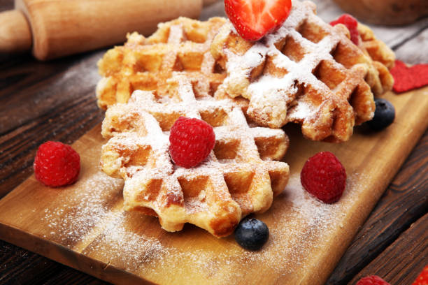 istock Traditional belgian waffles with fresh blueberries, sugar and raspberries on rustic table 1199435421