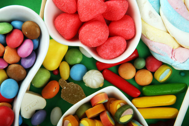 istock candies with jelly and sugar. colorful array of different childs sweets and treats on green background 1199435607