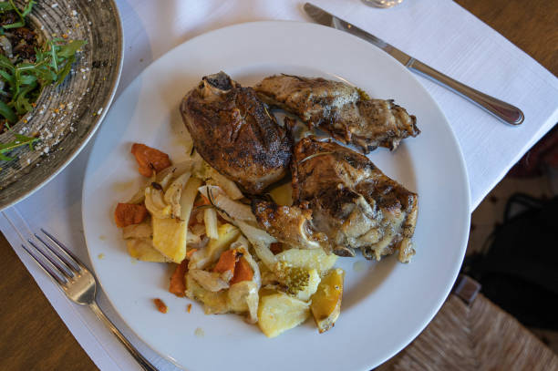 istock baked pork with potatoes and vegetables on a white plate, selective focus 1199437155