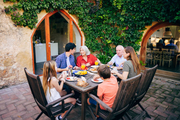 istock Relaxed Spanish family dining outdoors in lush courtyard 1199440178
