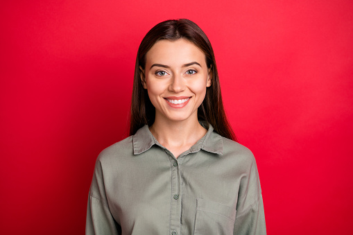 Close-up portrait of her she nice-looking attractive lovely lovable pretty, cheerful cheery straight-haired girl wearing khaki shirt isolated over bright vivid shine vibrant red color background